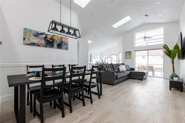 dining area with a healthy amount of sunlight, high vaulted ceiling, and a skylight