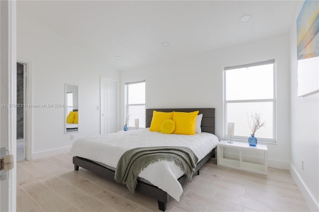 bedroom with light hardwood / wood-style flooring and multiple windows