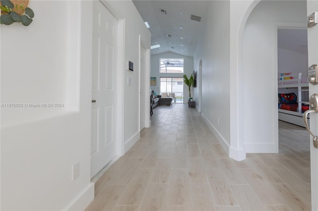 corridor featuring light hardwood / wood-style floors and lofted ceiling