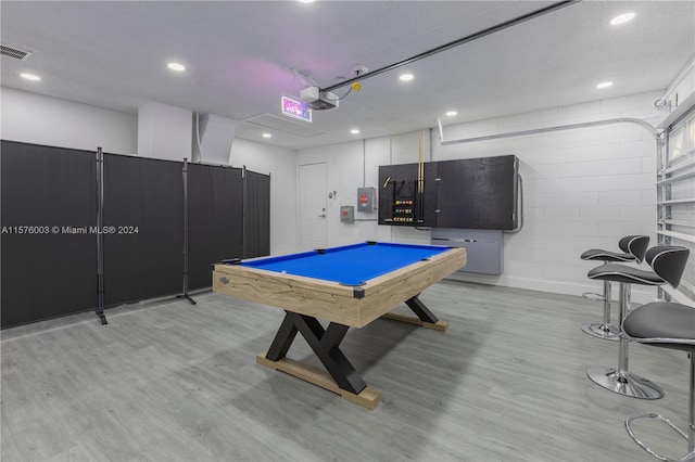 game room featuring electric panel, light hardwood / wood-style flooring, and billiards