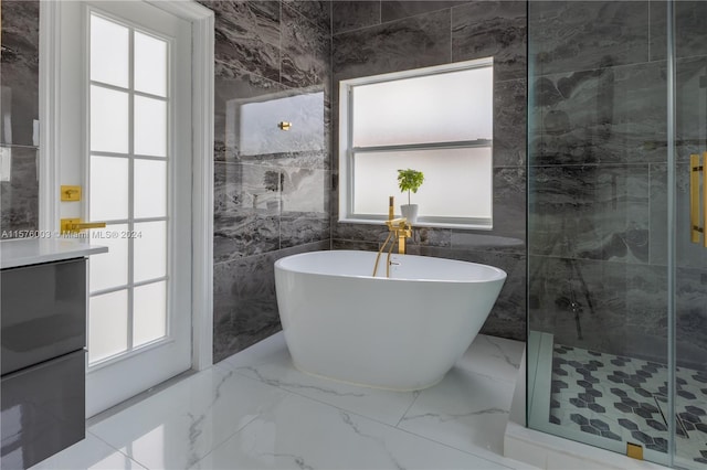 bathroom featuring shower with separate bathtub, tile walls, a healthy amount of sunlight, and tile patterned flooring