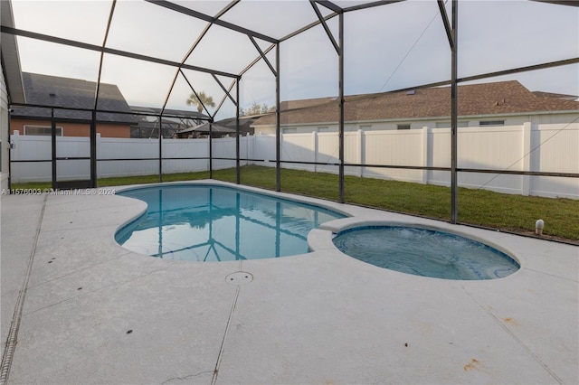 view of swimming pool with glass enclosure, a lawn, and a patio area