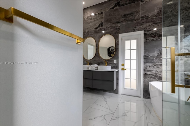 bathroom featuring tile patterned flooring, tile walls, a healthy amount of sunlight, and a tub