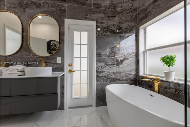 bathroom featuring vanity, tile walls, a tub, and tile patterned flooring