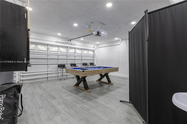 rec room featuring a textured ceiling, light hardwood / wood-style floors, and billiards