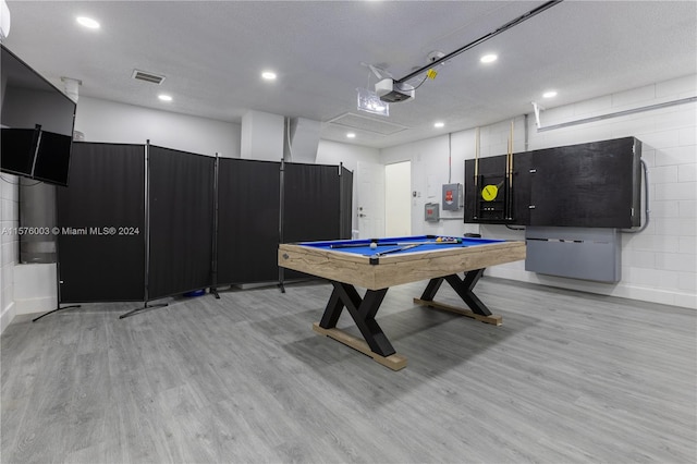 playroom featuring a textured ceiling, light hardwood / wood-style flooring, electric panel, and billiards