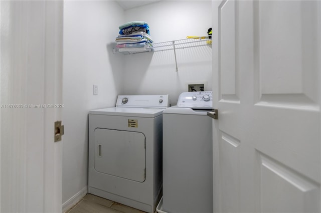 washroom with separate washer and dryer and light hardwood / wood-style floors