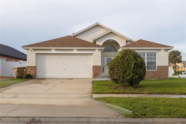 view of front of property featuring a garage and a front lawn