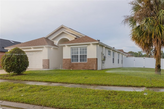 ranch-style home featuring a garage and a front lawn