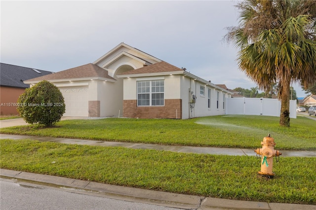 ranch-style home with a garage and a front yard