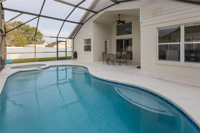 view of swimming pool with a patio area, ceiling fan, and glass enclosure