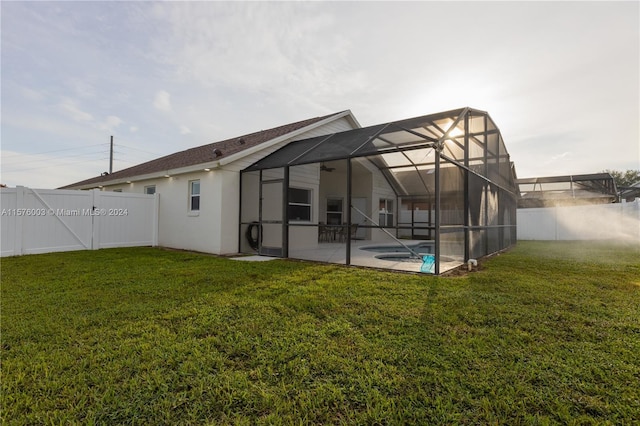 rear view of house with a yard, a fenced backyard, a patio, and a lanai