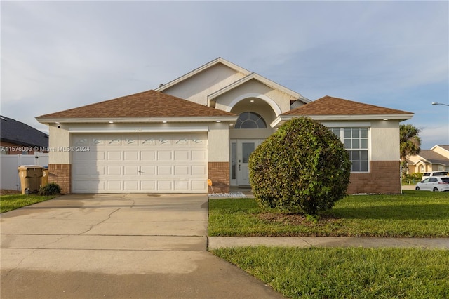 view of front of home with a garage and a front lawn