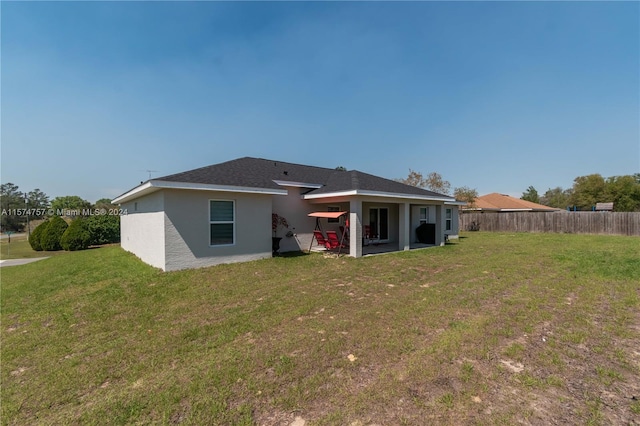 rear view of house featuring a patio and a yard