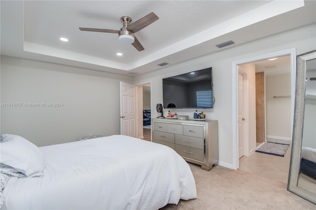 carpeted bedroom featuring ceiling fan and a raised ceiling