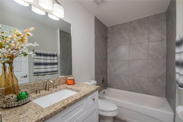 full bathroom featuring tiled shower / bath combo, toilet, and vanity