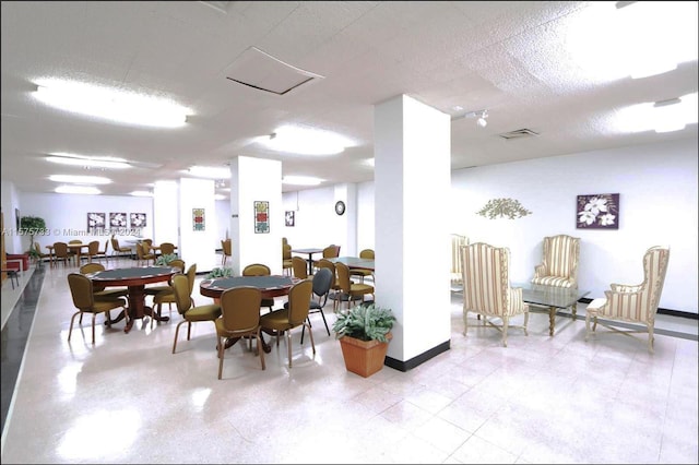 dining space with a textured ceiling and light tile floors