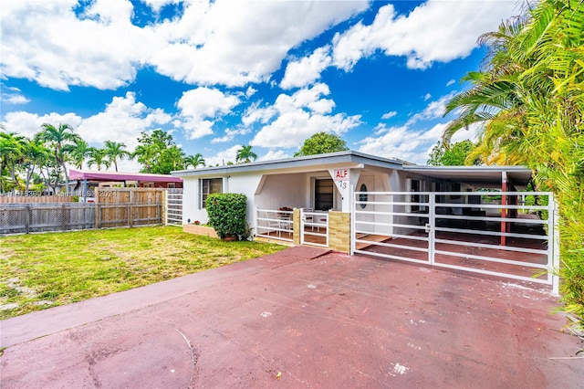 view of front of house with a carport and a front lawn