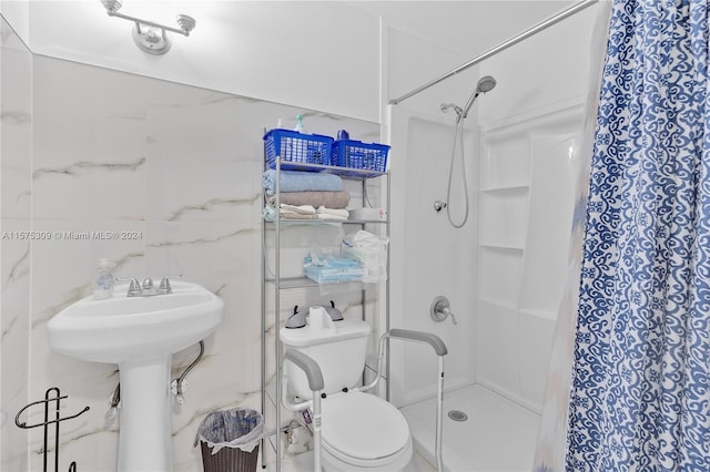 bathroom featuring walk in shower, toilet, and tile walls