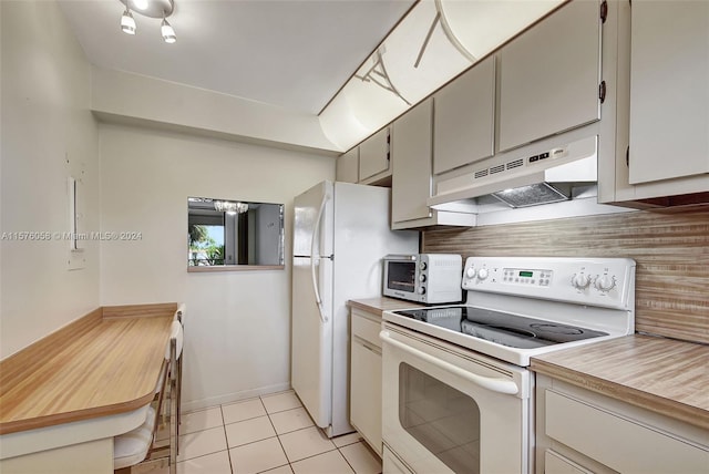 kitchen featuring light tile patterned flooring, white appliances, and tasteful backsplash