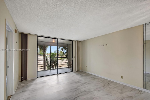 empty room featuring a textured ceiling and floor to ceiling windows