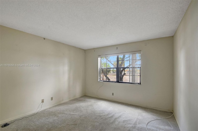 carpeted spare room featuring a textured ceiling