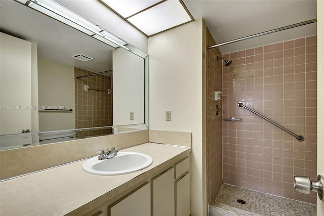 bathroom with vanity and tiled shower