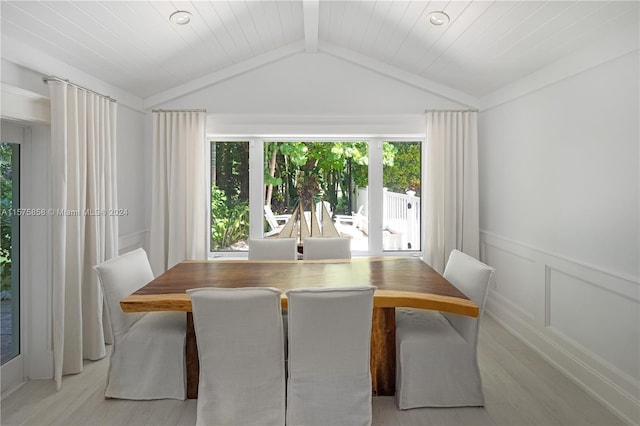 dining space featuring vaulted ceiling with beams, wooden ceiling, plenty of natural light, and light hardwood / wood-style floors