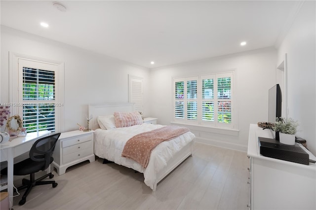 bedroom featuring crown molding and light wood-type flooring