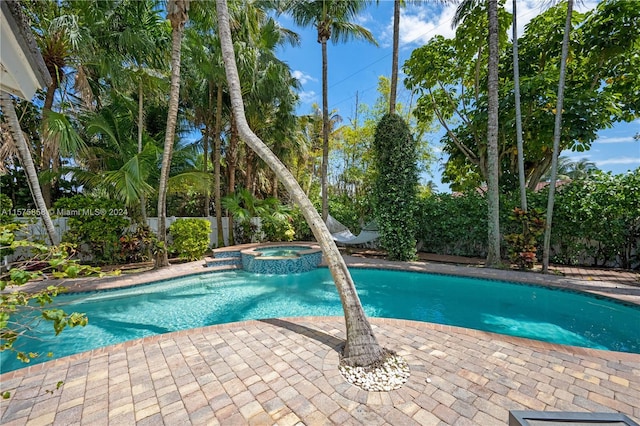 view of swimming pool featuring an in ground hot tub and a patio