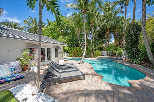 view of pool featuring a patio, french doors, and an in ground hot tub