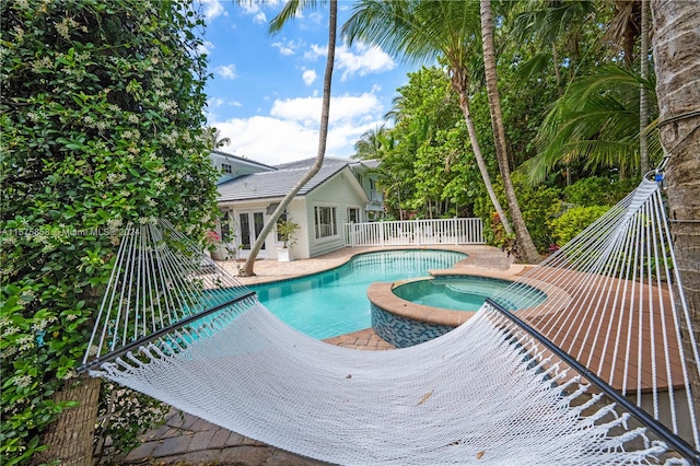 view of swimming pool with a patio and an in ground hot tub