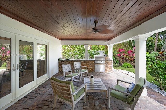 view of terrace featuring french doors, ceiling fan, an outdoor kitchen, and grilling area