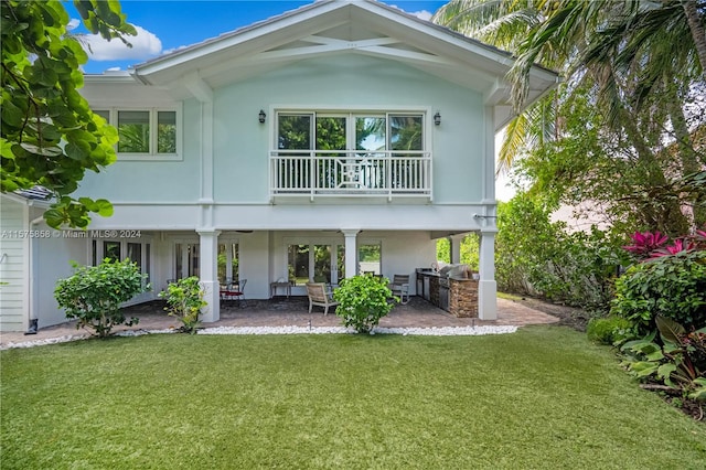 back of house with a balcony and a lawn