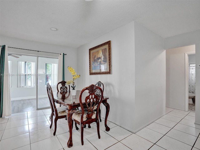 dining space featuring a textured ceiling, ceiling fan, and light tile floors