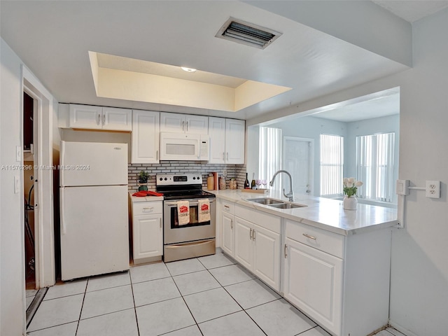 kitchen with sink, white appliances, light tile flooring, and white cabinetry