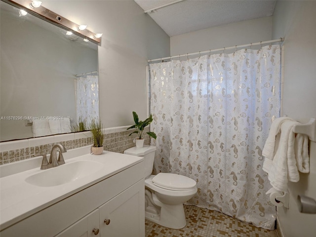 bathroom featuring vanity, backsplash, tile flooring, toilet, and a textured ceiling