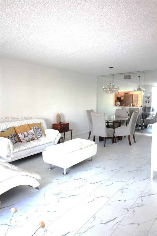 living room featuring a chandelier and a textured ceiling