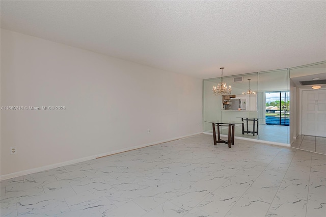 unfurnished room with marble finish floor, baseboards, visible vents, and a notable chandelier