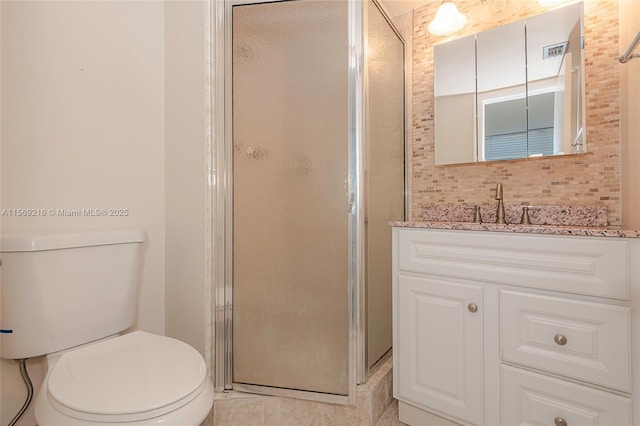 bathroom with backsplash, a shower stall, toilet, and vanity