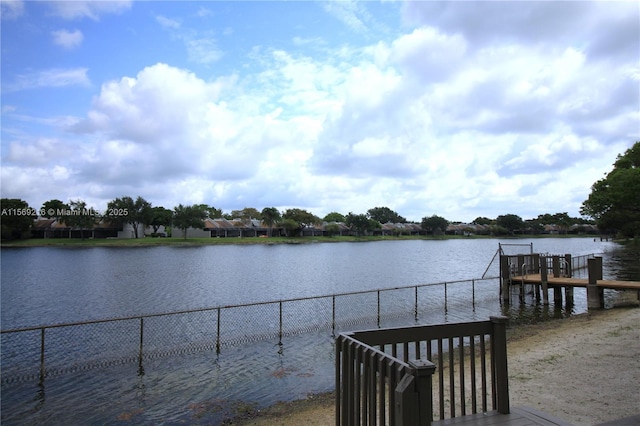 view of dock featuring a water view and fence