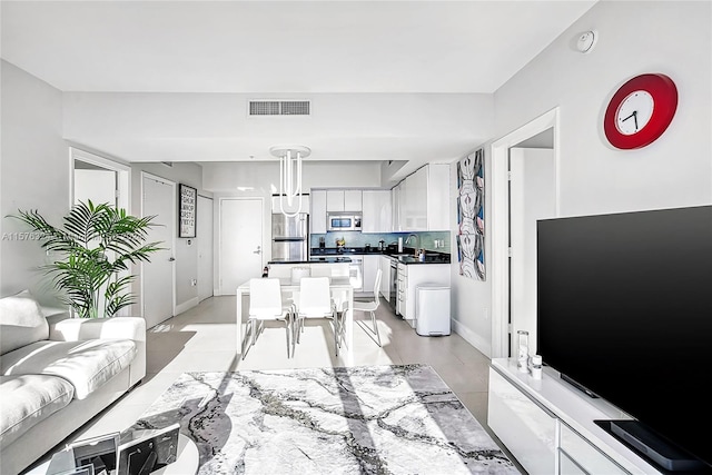 living room featuring light tile floors and sink