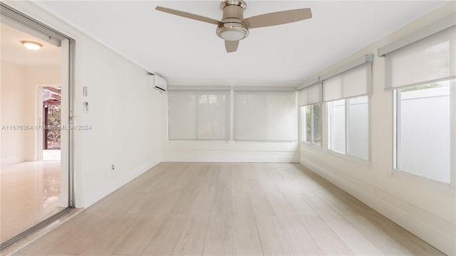 unfurnished sunroom with a wall unit AC and ceiling fan