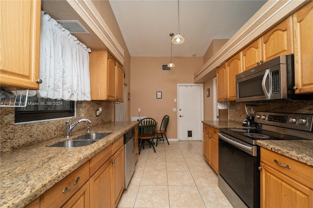 kitchen featuring sink, light stone counters, decorative backsplash, light tile patterned floors, and appliances with stainless steel finishes