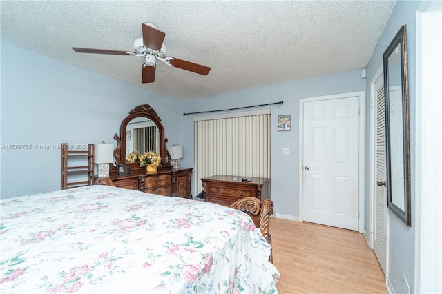 bedroom featuring ceiling fan, a textured ceiling, and light wood-type flooring