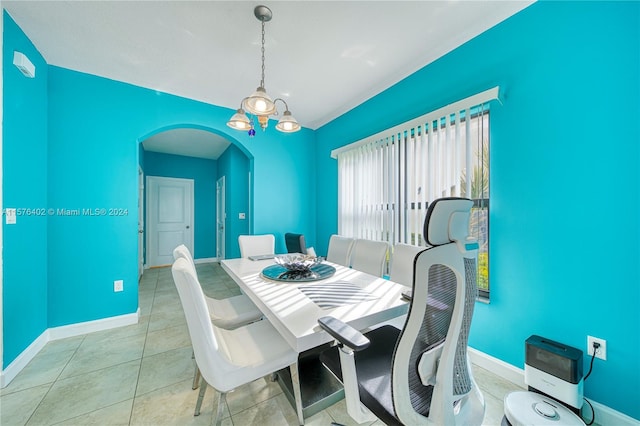 dining room featuring tile flooring and a notable chandelier