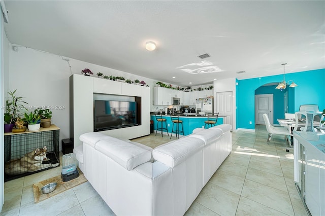 tiled living room featuring a chandelier