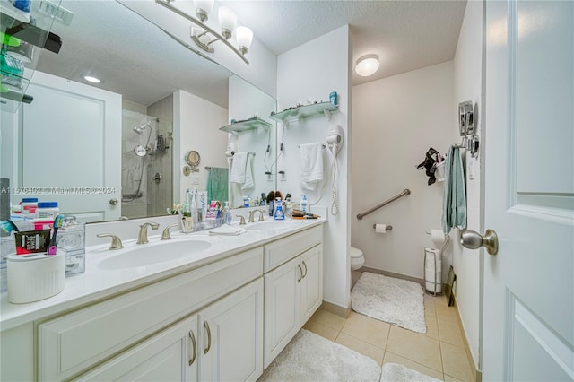 bathroom with a shower with door, large vanity, toilet, tile flooring, and a textured ceiling