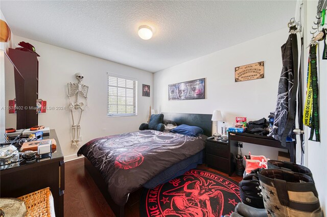 bedroom with hardwood / wood-style floors and a textured ceiling