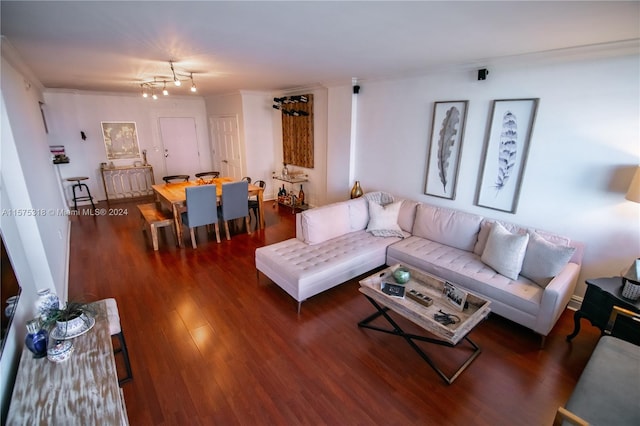 living room with dark hardwood / wood-style flooring, crown molding, and a notable chandelier